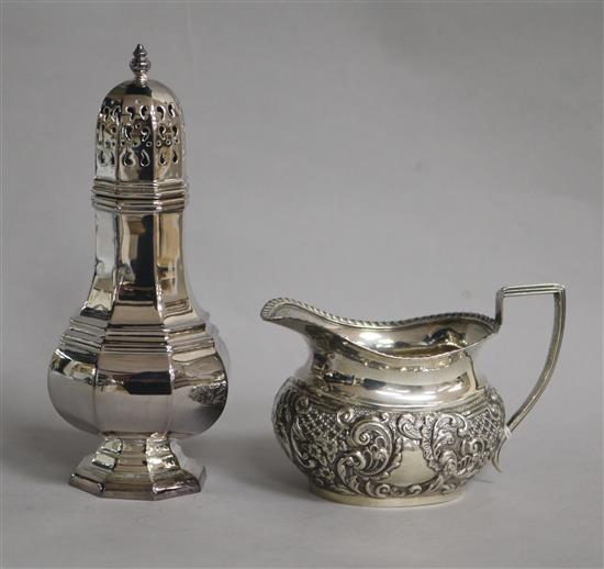 A late Victorian repousse silver cream jug and a later silver sugar caster, 8.5 oz.